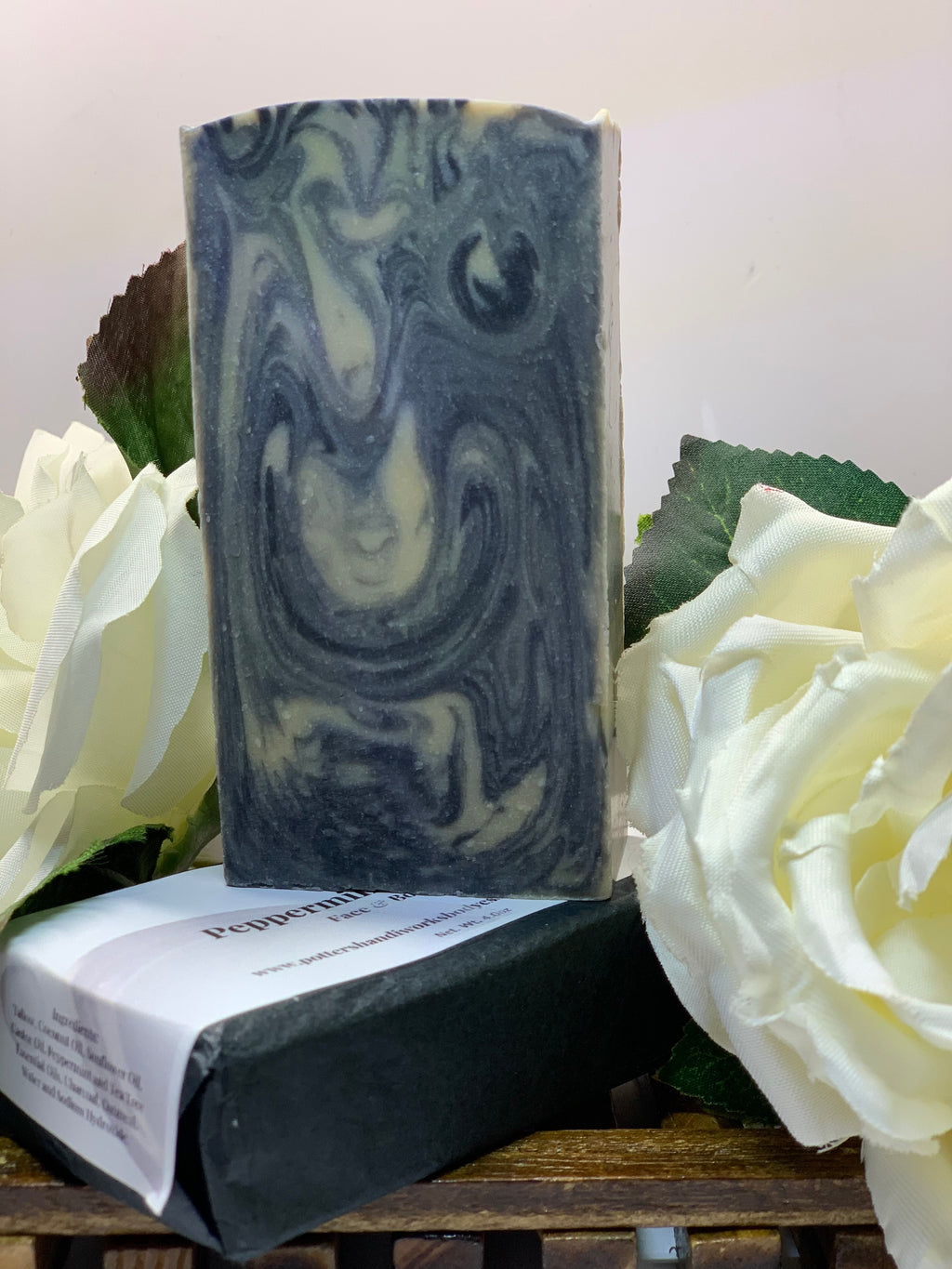 Bar of soap with a swirl pattern on a white background with white flowers