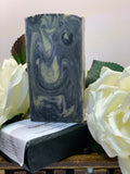 Bar of soap with a swirl pattern on a white background with white flowers